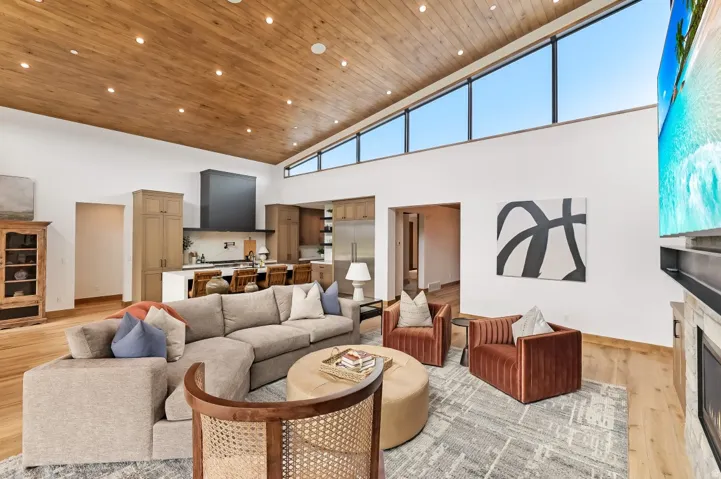 Vaulted wood-finish ceiling, wood-finish flooring, a contemporary fireplace, and a kitchen with built-in cabinetry