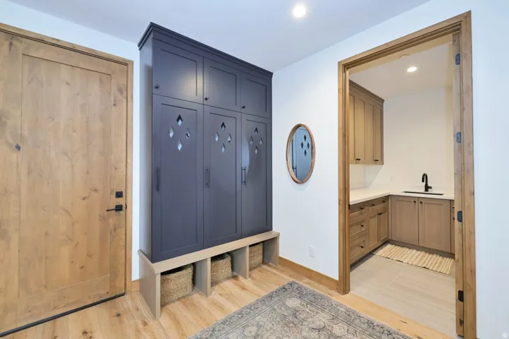 Wood-finish flooring with a contrasting built-in storage unit featuring decorative cutouts