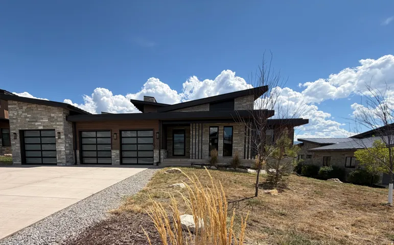 Contemporary exterior with stone veneer and dark trim