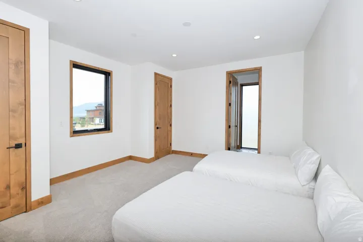 Recessed lighting, wood-finish doors, wood-finish window trim, and light-toned carpeting