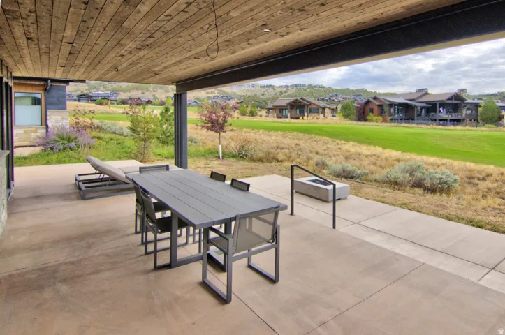Covered patio with a wood-finish ceiling, concrete flooring, and an integrated fire pit