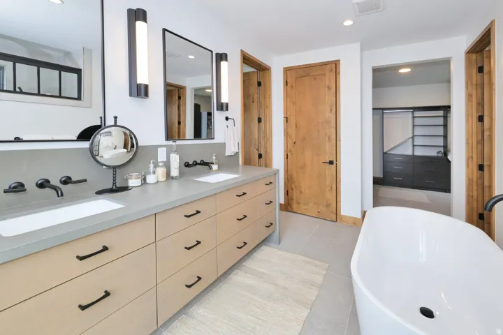 Double vanity with a light-toned countertop, dual rectangular sinks, and matte black wall-mounted faucets