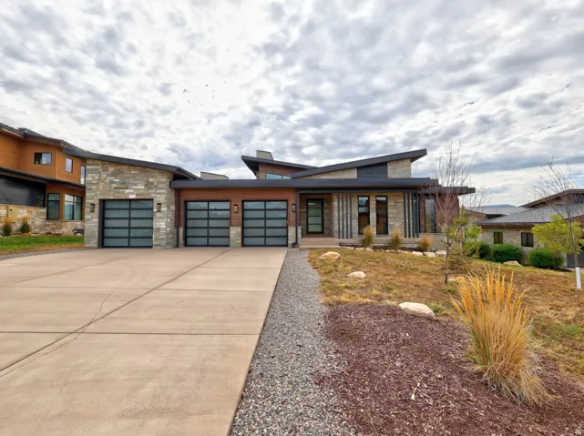 Modern architectural design featuring stone and wood-finish siding