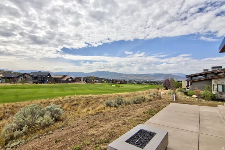 Expansive lawn with native landscaping and mature sagebrush plantings overlooking rolling terrain and distant mountain ranges