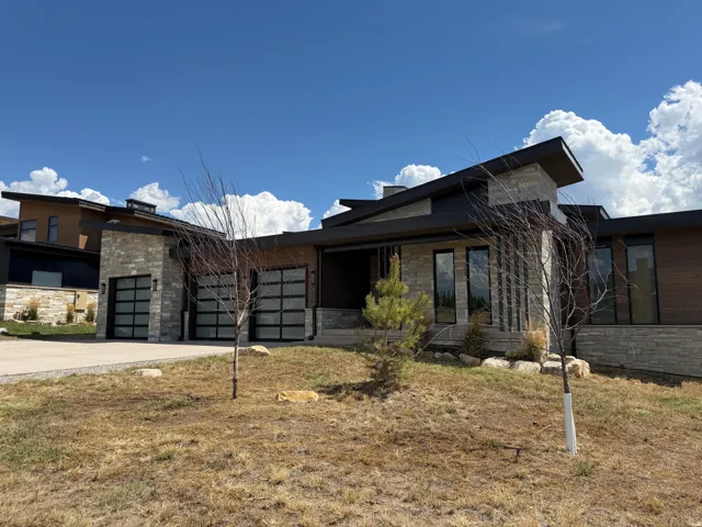 Modern architectural design featuring stone and wood-finish siding