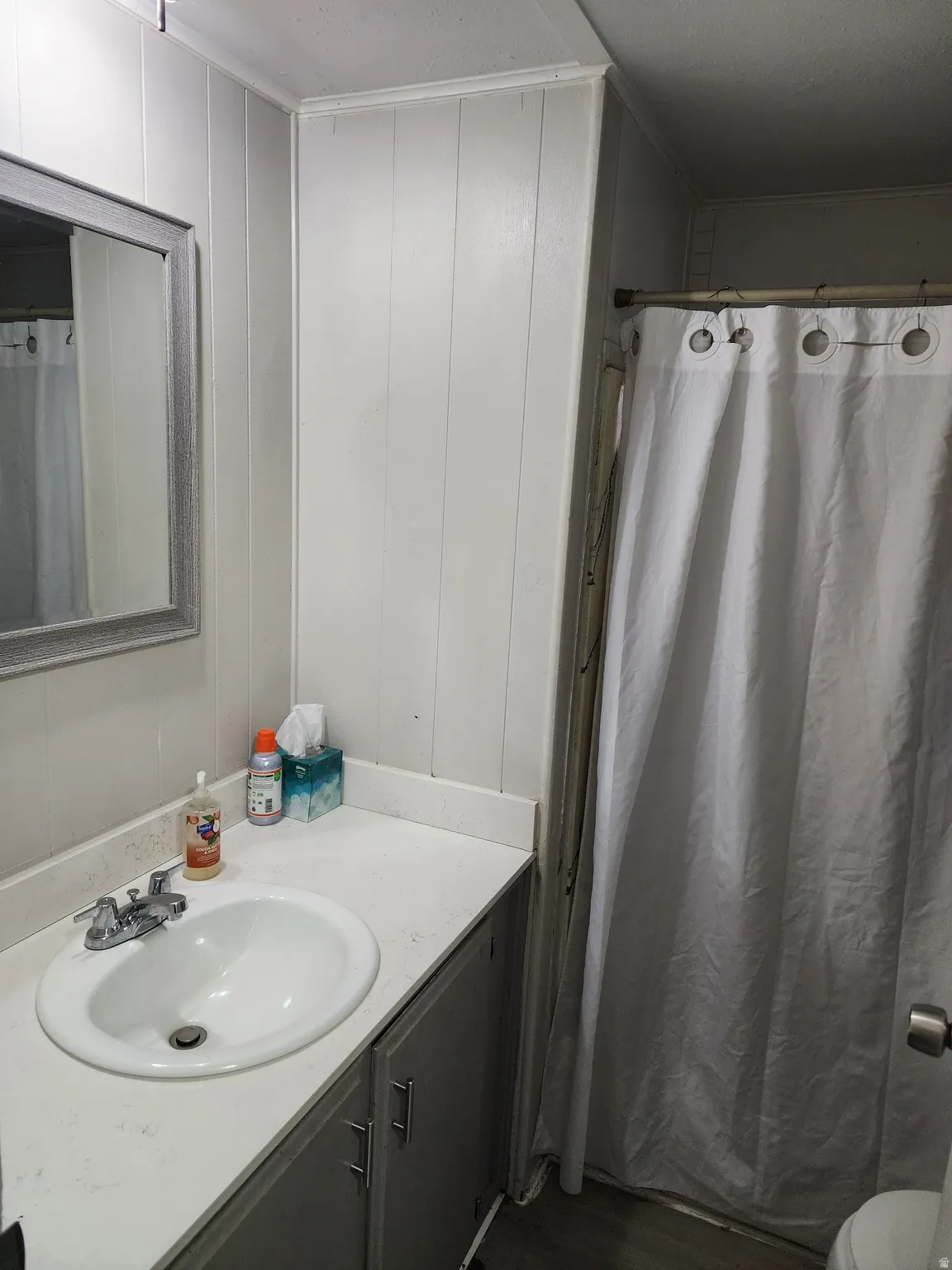 Single vanity with an integrated sink, chrome faucet, and gray cabinetry