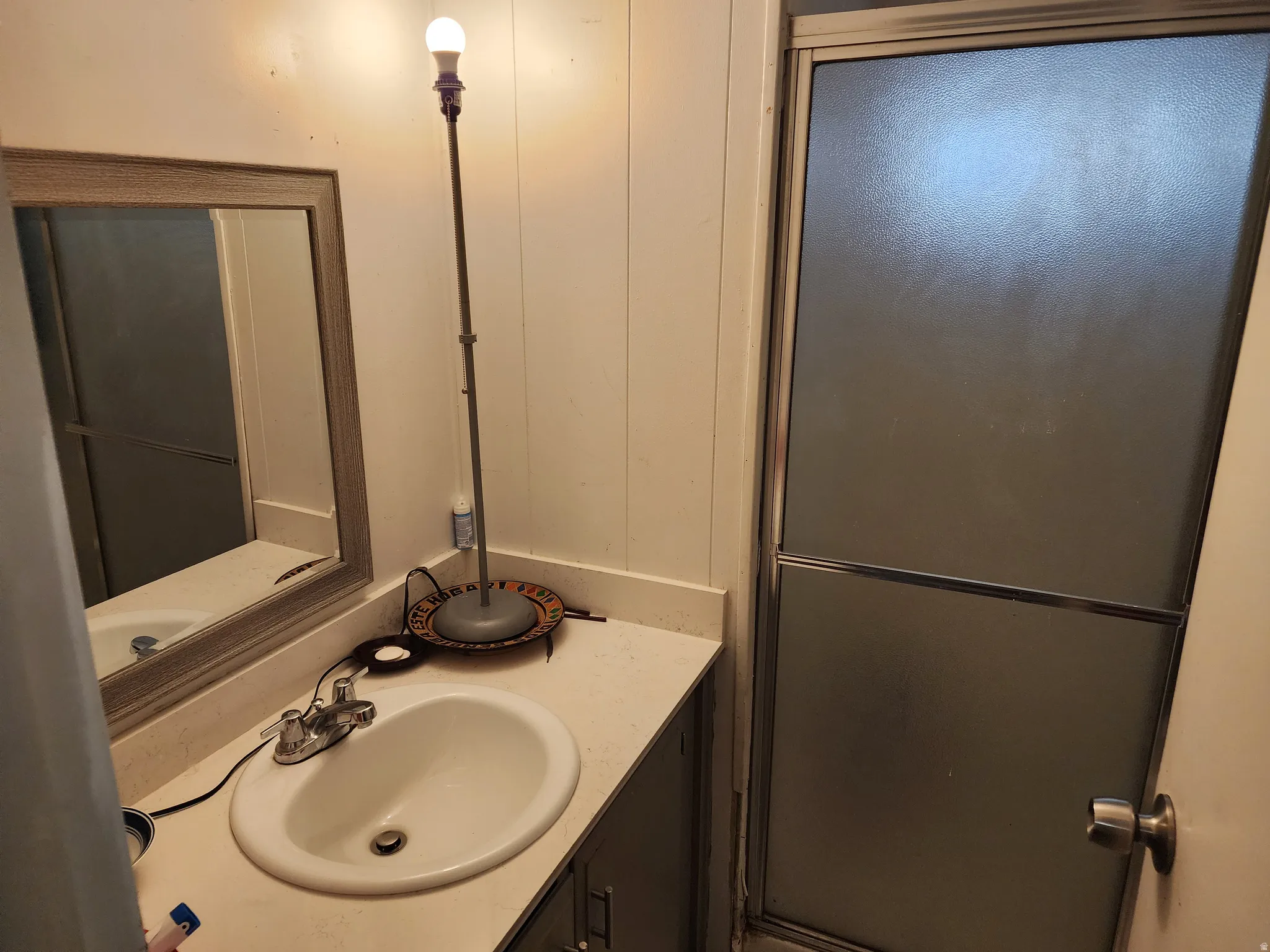 Vanity with integrated sink, chrome-finish faucet, and a framed mirror