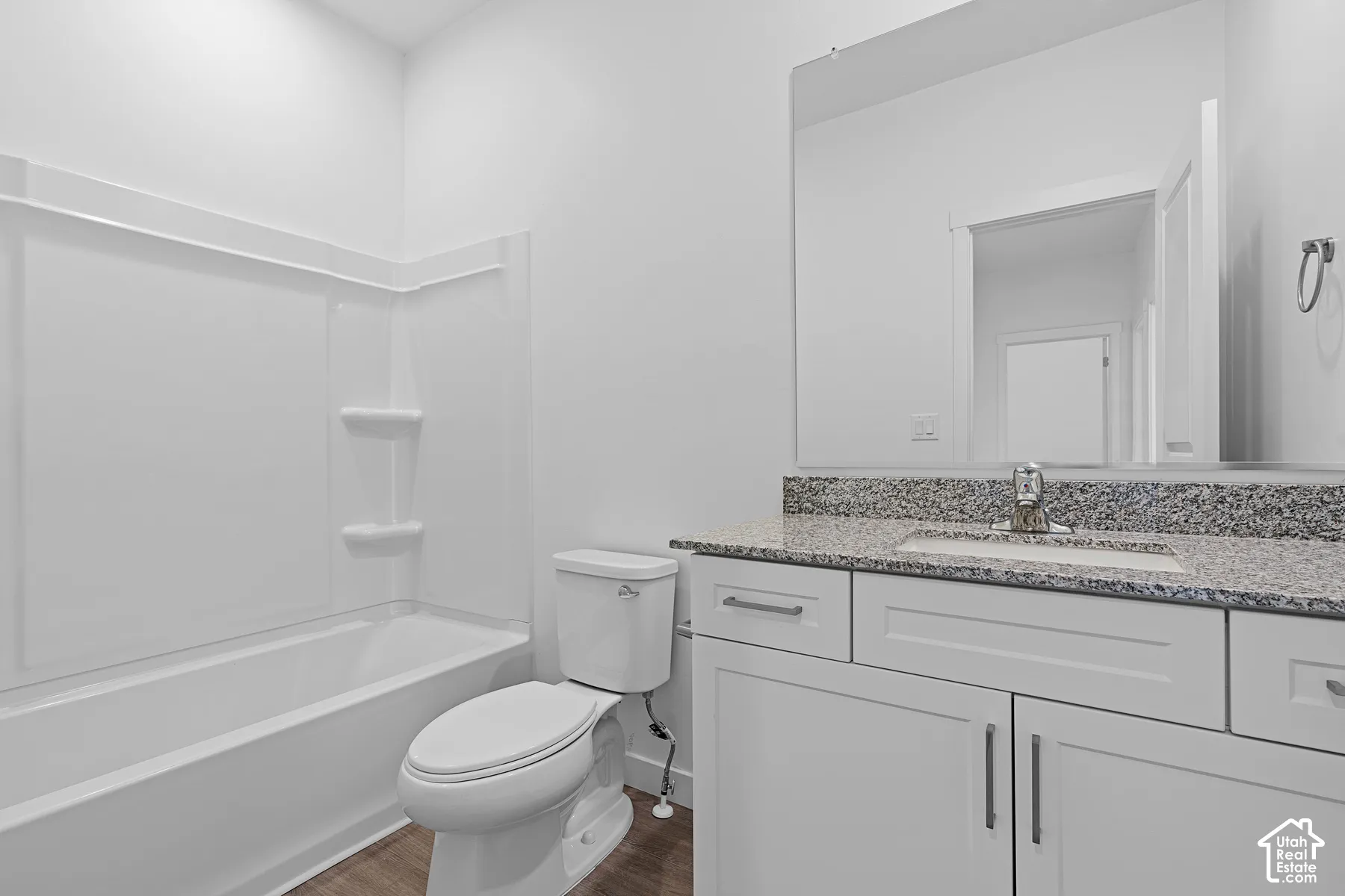 White vanity with a light granite countertop and undermount sink