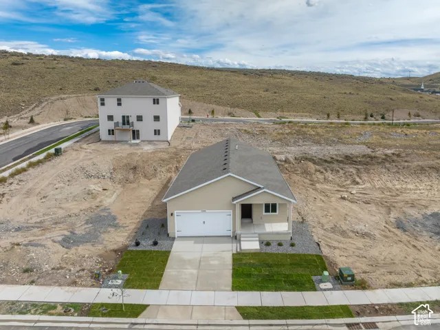Newly constructed residence with a concrete driveway and an attached garage