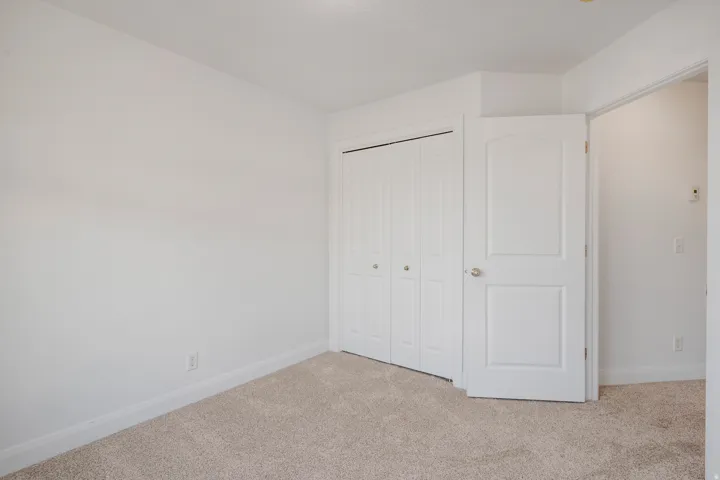 Neutral color palette, plush carpet flooring, white interior doors, bifold closet doors