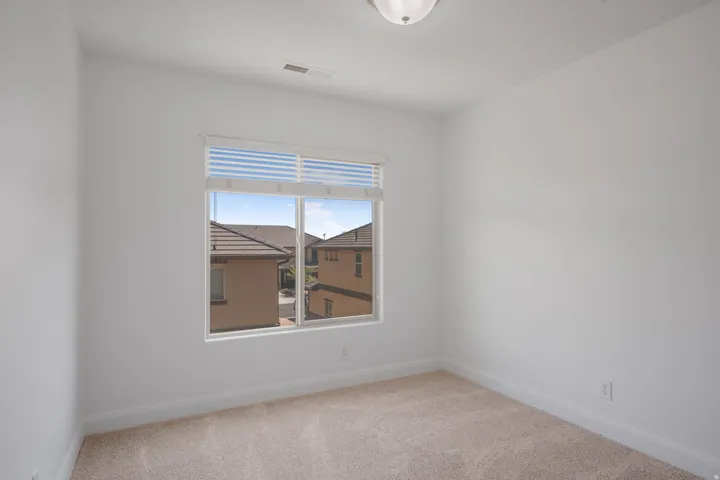 White walls with a single window featuring horizontal blinds