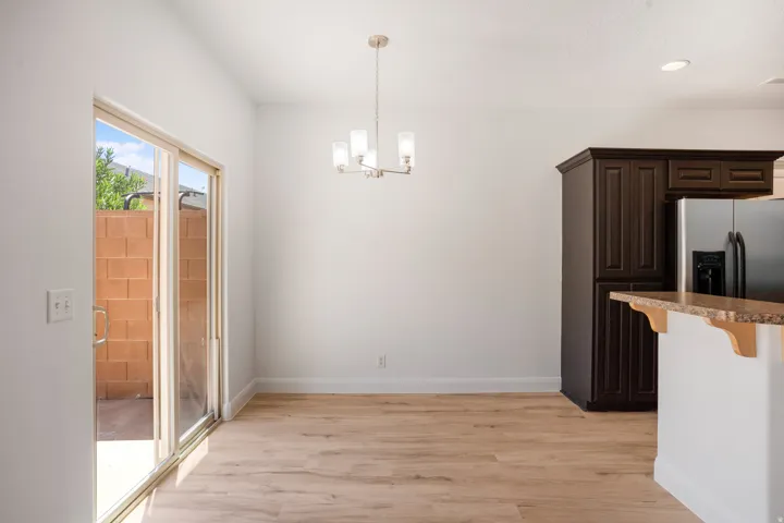 Wood-finish flooring, sliding glass door, recessed lighting, built-in cabinetry, and a bar-height counter