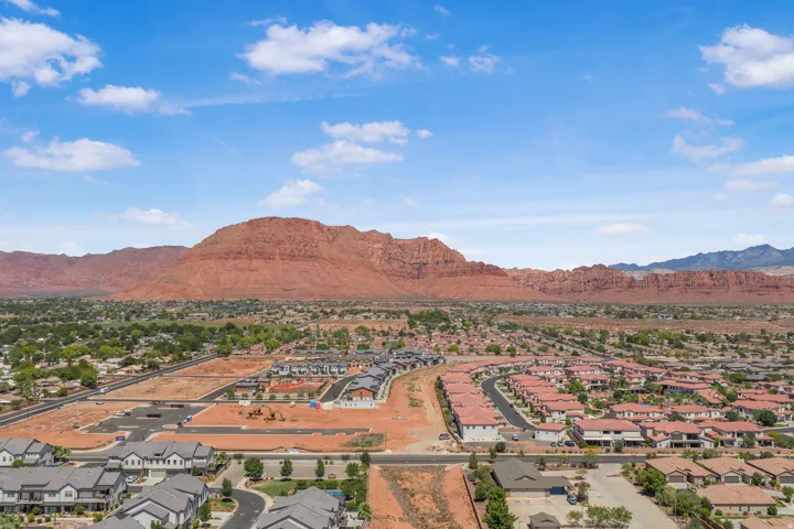 Expansive residential development featuring red rock mountain backdrop, established neighborhoods, and areas under construction