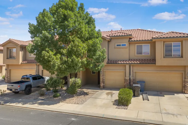 Multi-story stucco exterior with tile roofing, attached garages, and paved driveways