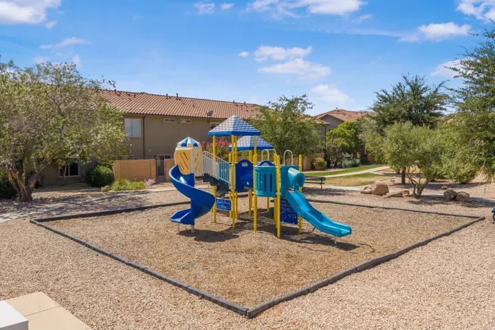 Outdoor play structure featuring multiple slides, climbing elements, and a covered platform