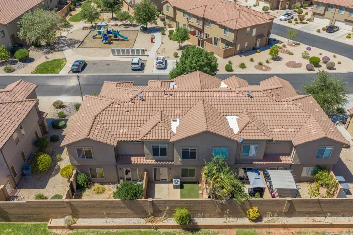 Terracotta tile roofing, stucco exterior, rear patio, fenced yard, and an adjacent community playground