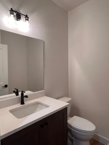 Modern vanity with dark wood-finish cabinetry, integrated rectangular sink, and light countertop