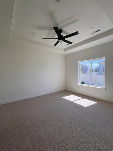 Recessed lighting, tray ceiling, black ceiling fan, and carpet flooring