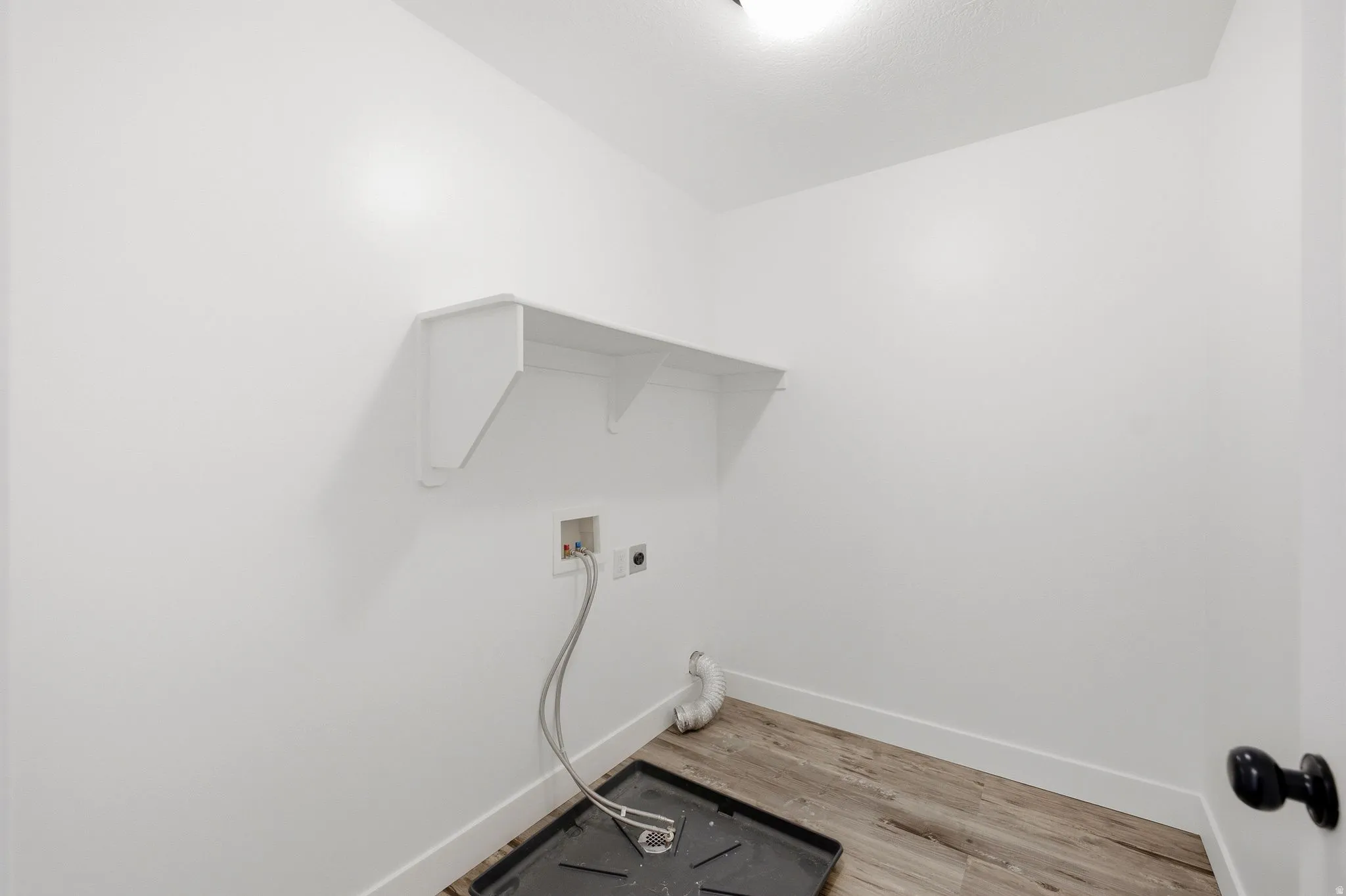 White walls, wood-finish flooring, and a built-in shelf