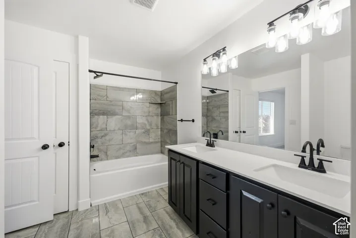 Dual vanity with dark cabinetry, white countertops, and matte black fixtures