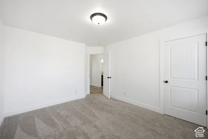 Neutral wall tones, gray carpeting, and a flush-mount ceiling light fixture