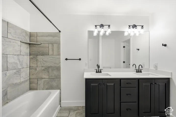 Double vanity with dark wood-finish cabinetry, white countertop, and matte black fixtures