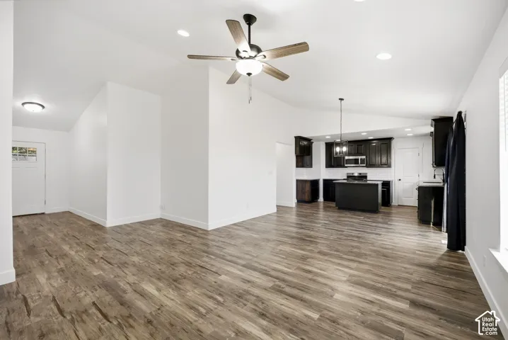 Open-concept living space featuring wood-finish flooring, a ceiling fan, and recessed lighting
