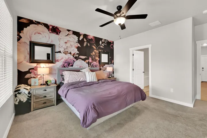 Accent wall featuring a floral pattern, recessed lighting, and a ceiling fan with light fixture