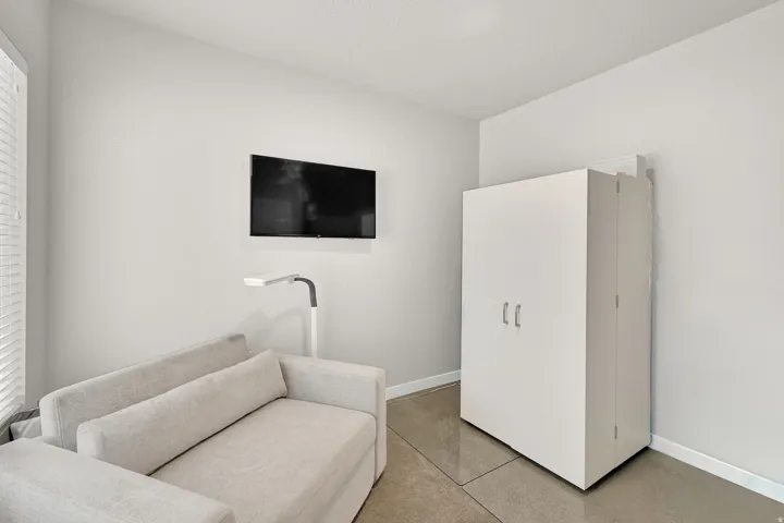 Wall-mounted television, neutral wall paint, and hard surface flooring