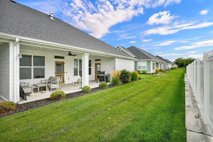 Covered patio with a ceiling fan, white siding, and a fenced perimeter