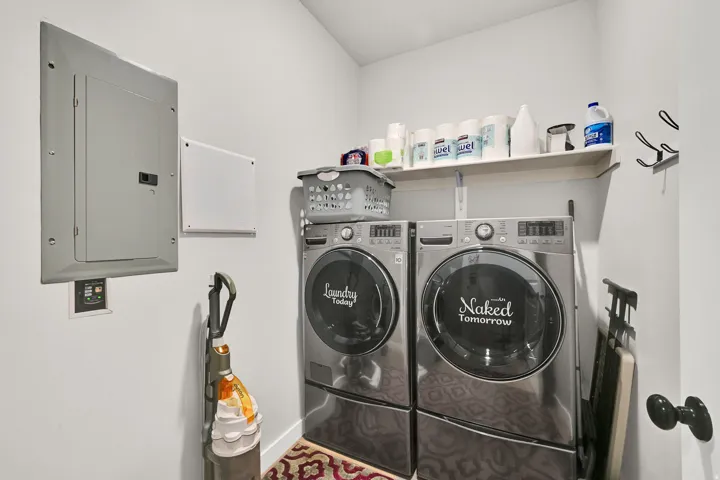 Dedicated laundry area with wall-mounted shelving and a utility panel