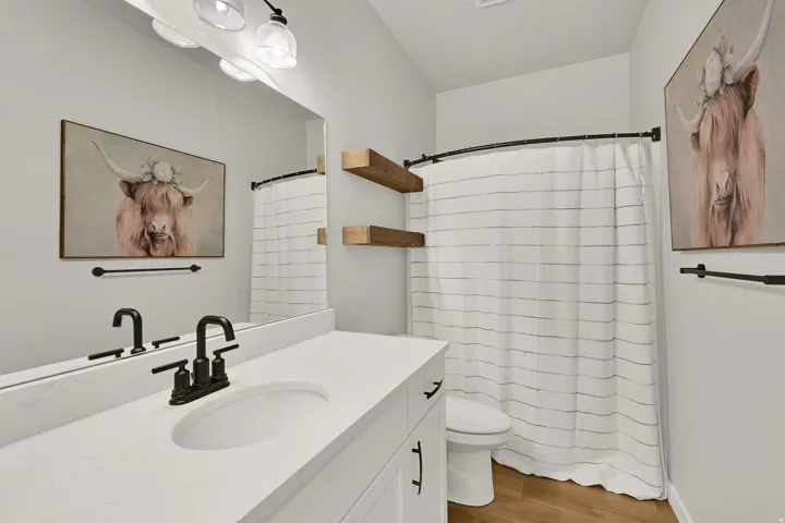 White vanity with integrated sink, matte black faucet, and coordinating hardware