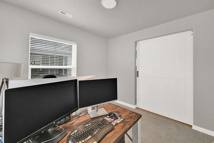 Recessed window with horizontal blinds, white barn door, and neutral wall color