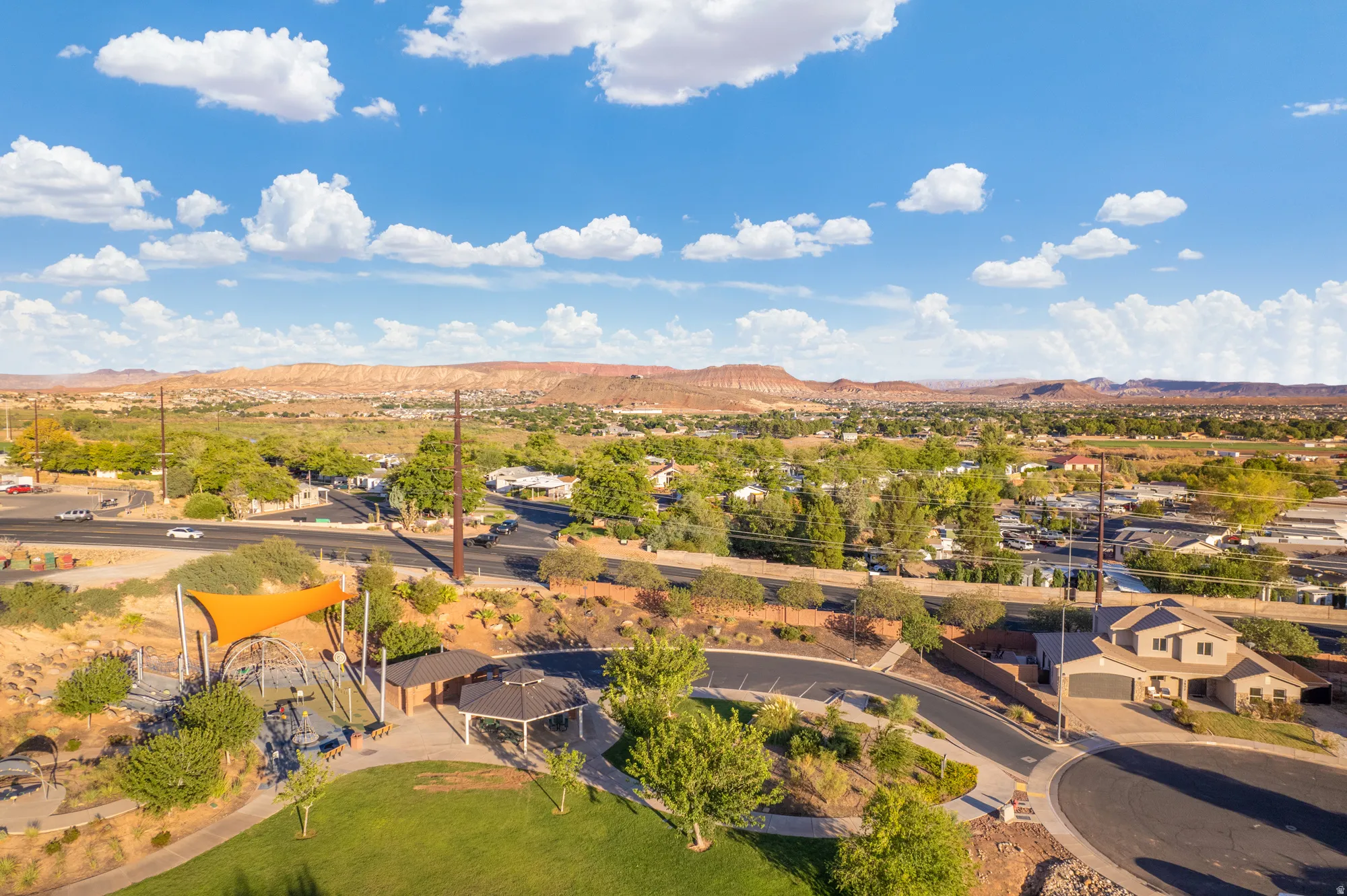 Expansive neighborhood with a community park featuring a playground and shaded picnic areas