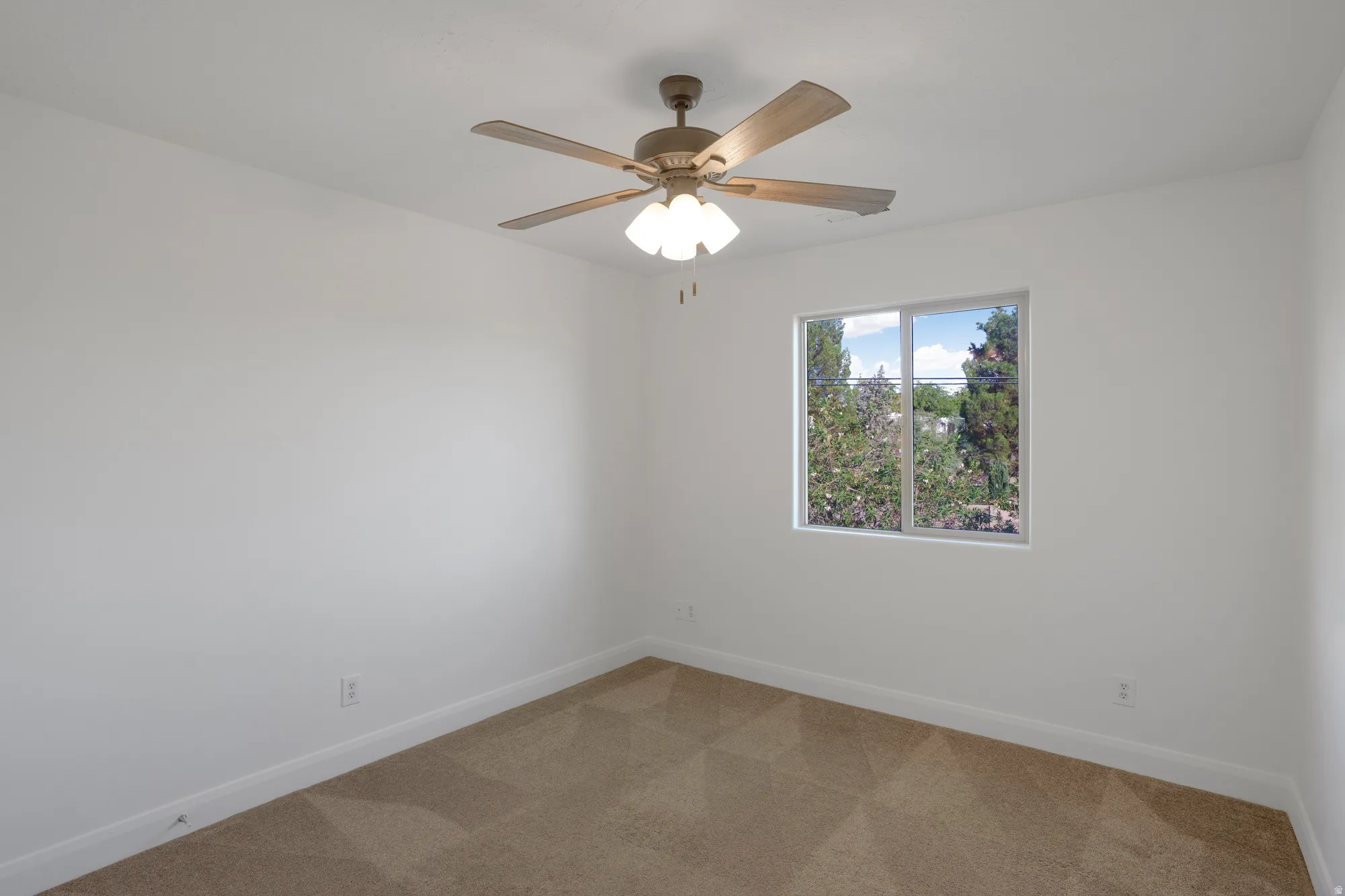 Neutral wall finishes, textured carpeting, and a ceiling fan with integrated lighting
