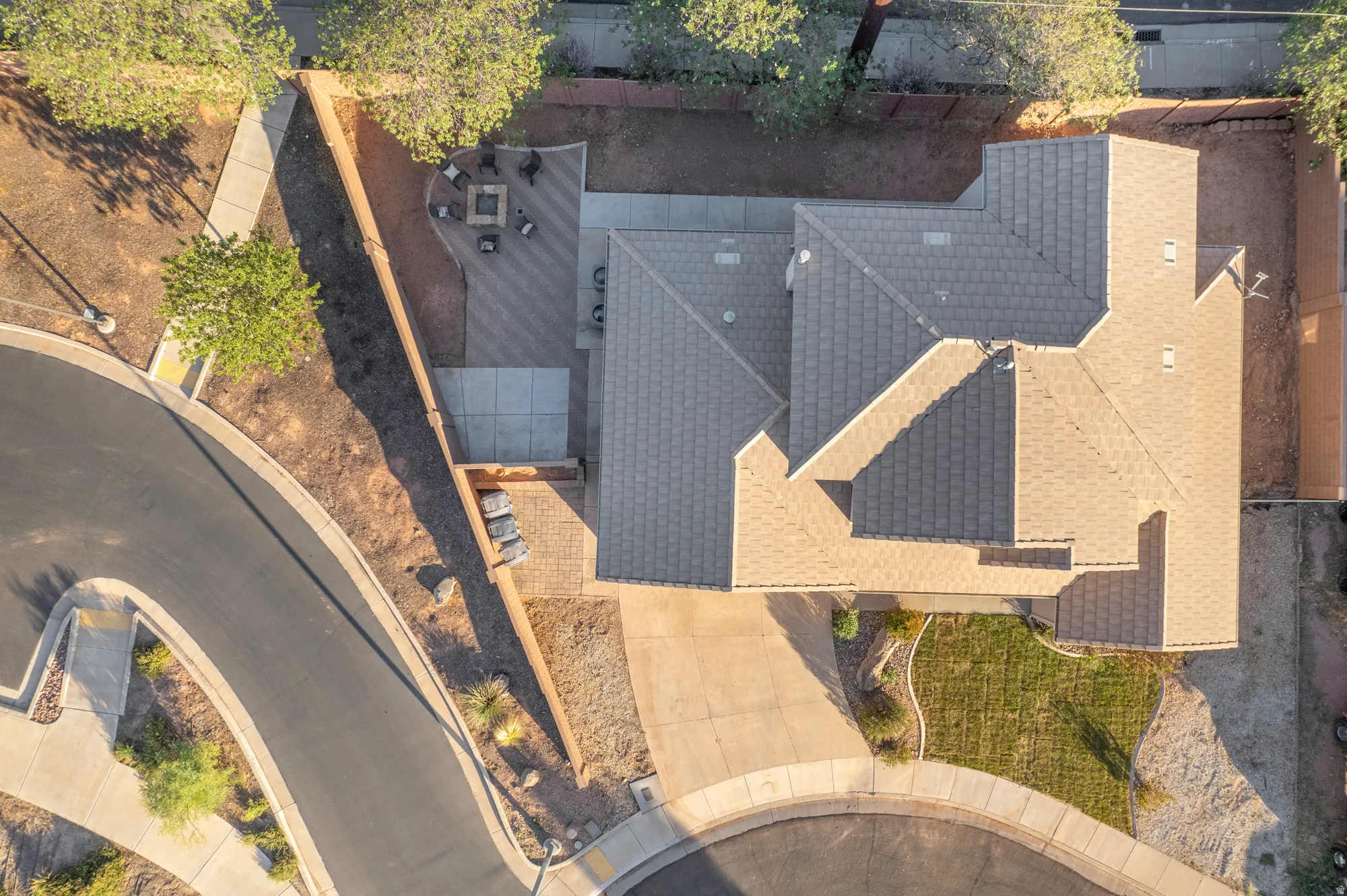 Paved driveway leading to a multi-gable roofline residence with a front lawn area