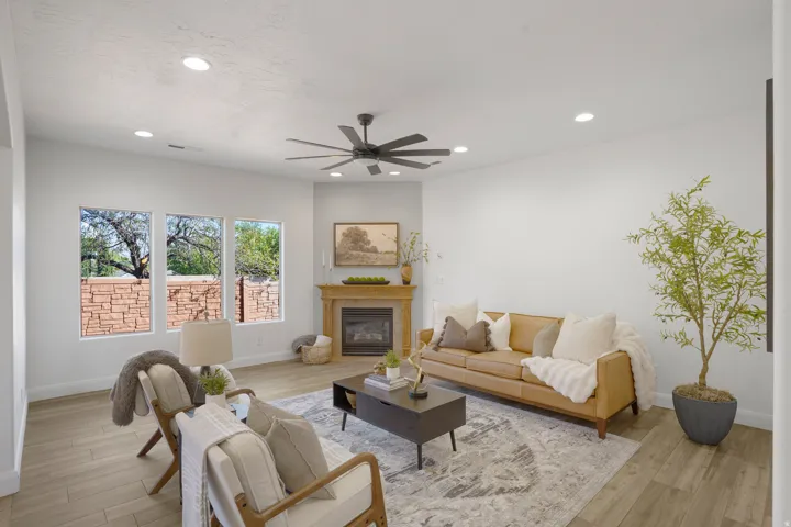 Recessed ceiling lighting, a ceiling fan, and light wood-finish flooring