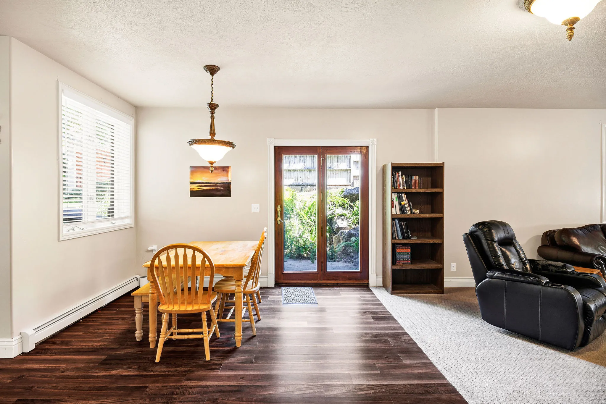 Wood-finish flooring, white trim, and a window with blinds
