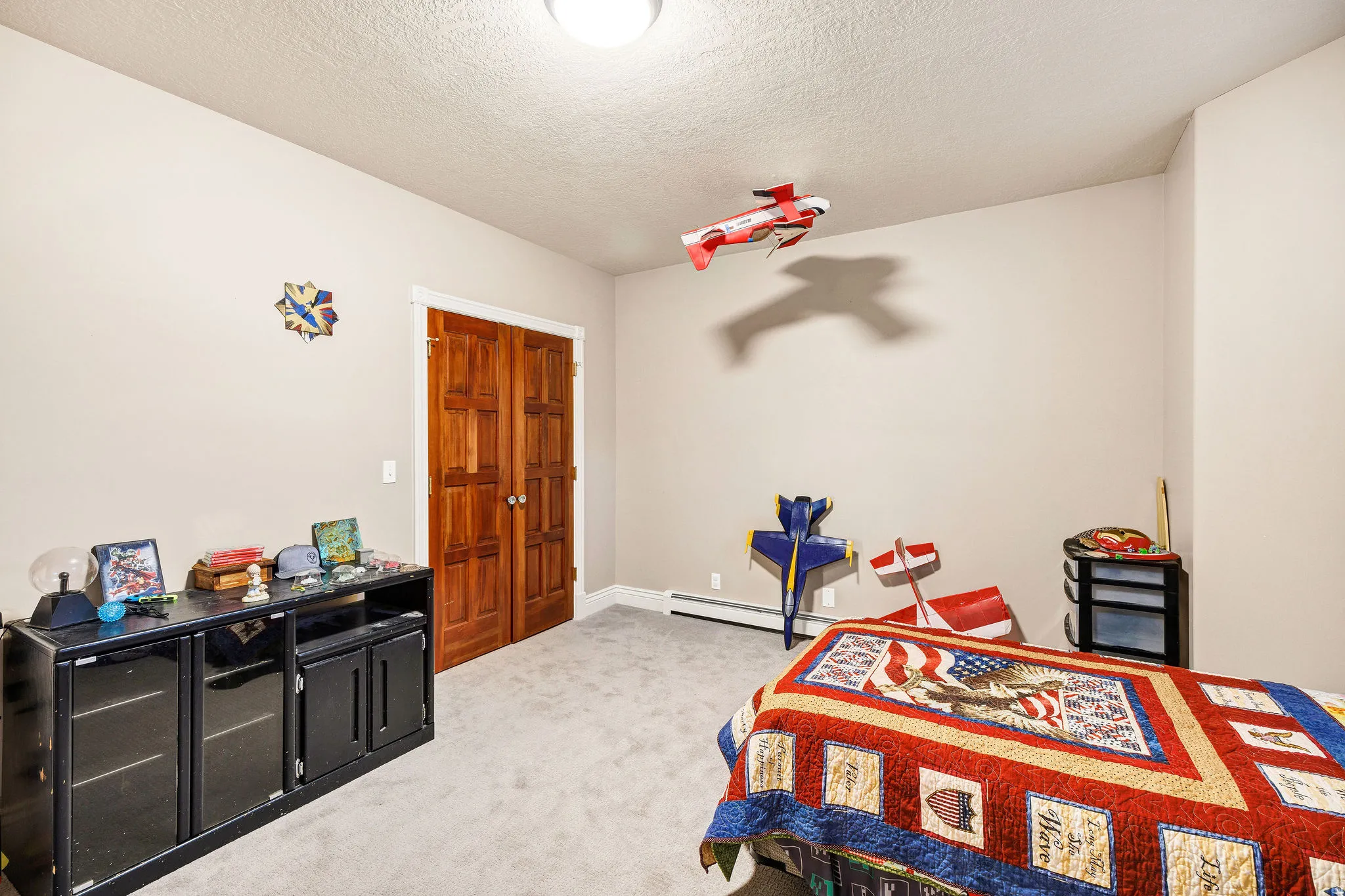 Neutral wall paint, light-colored carpeting, and wood-panel bifold doors