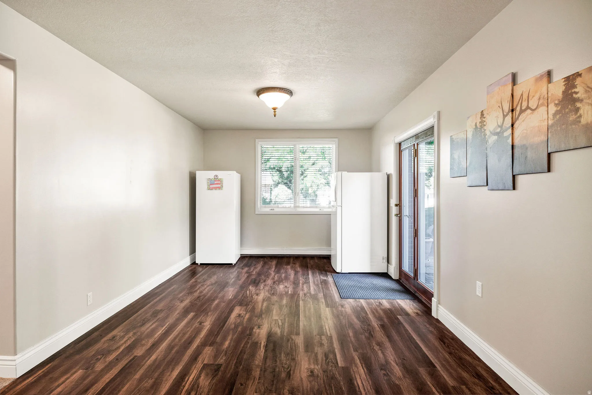 Wood-finish flooring, white trim, recessed window with blinds, and white walls