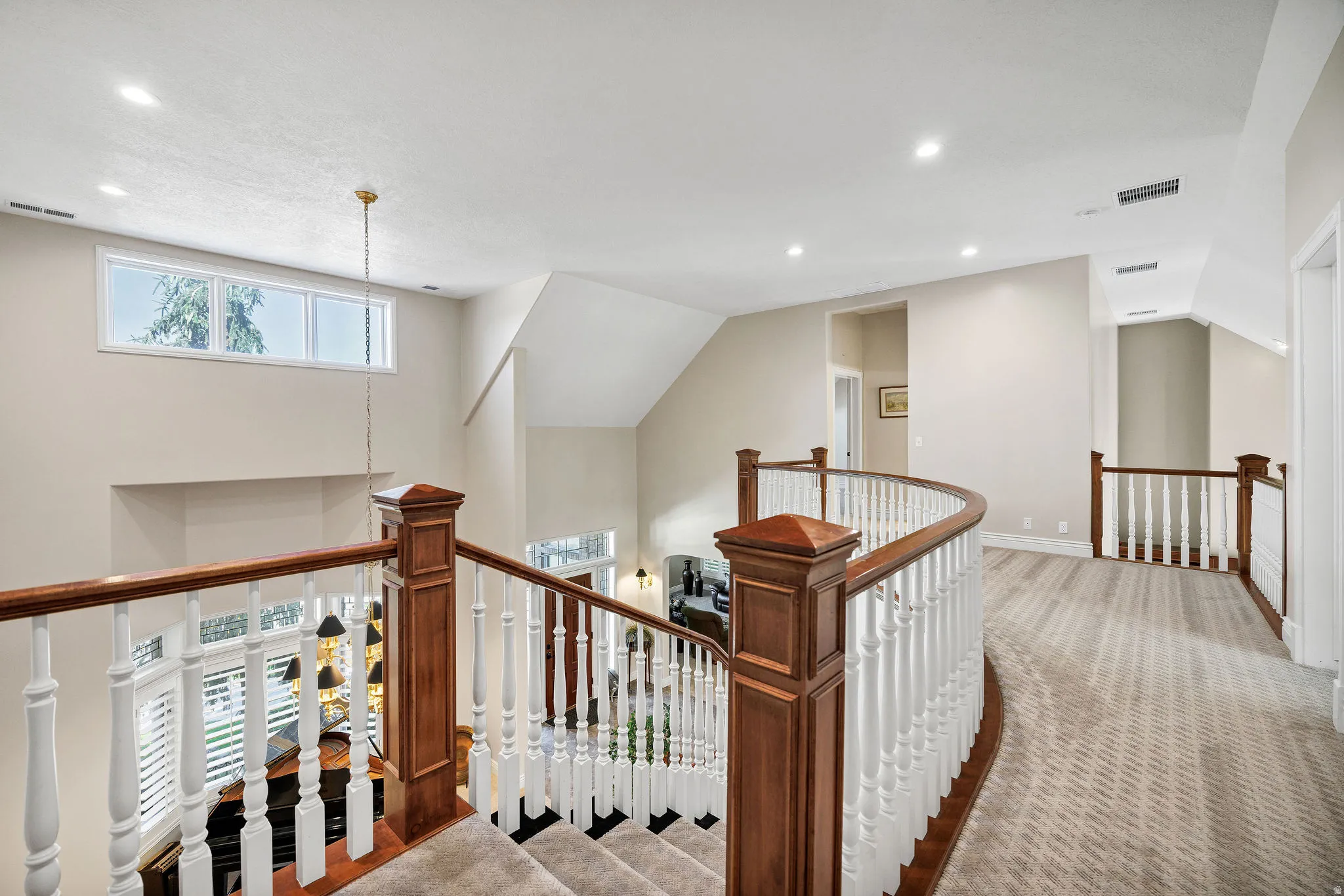 Curved staircase featuring wood newel posts and white balusters