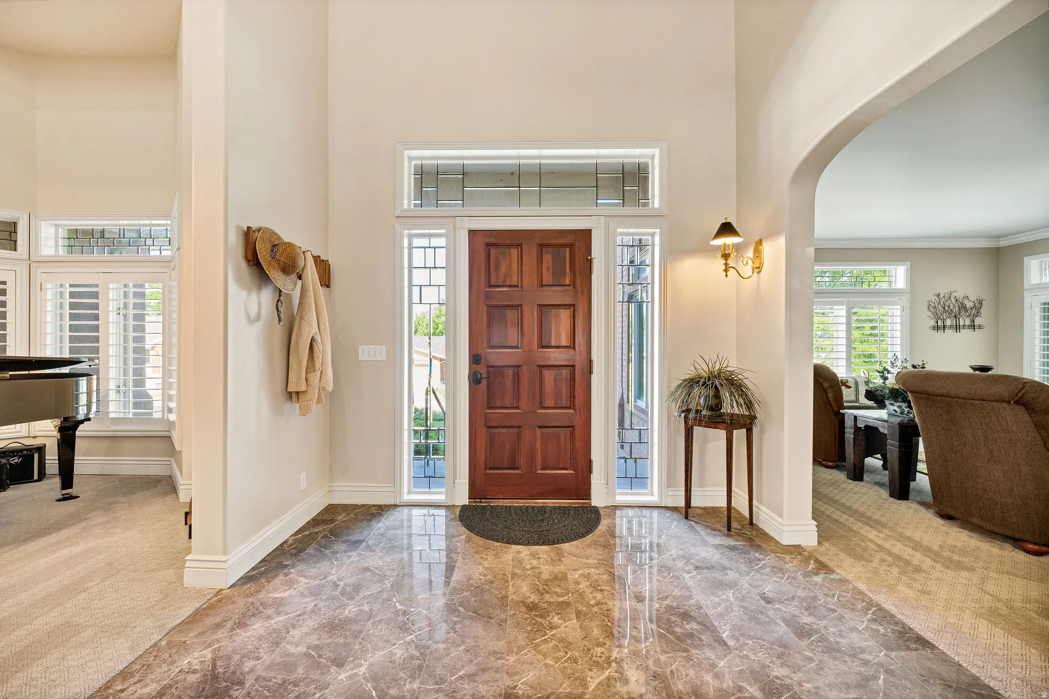 Grand entry featuring polished marble flooring and a solid wood front door