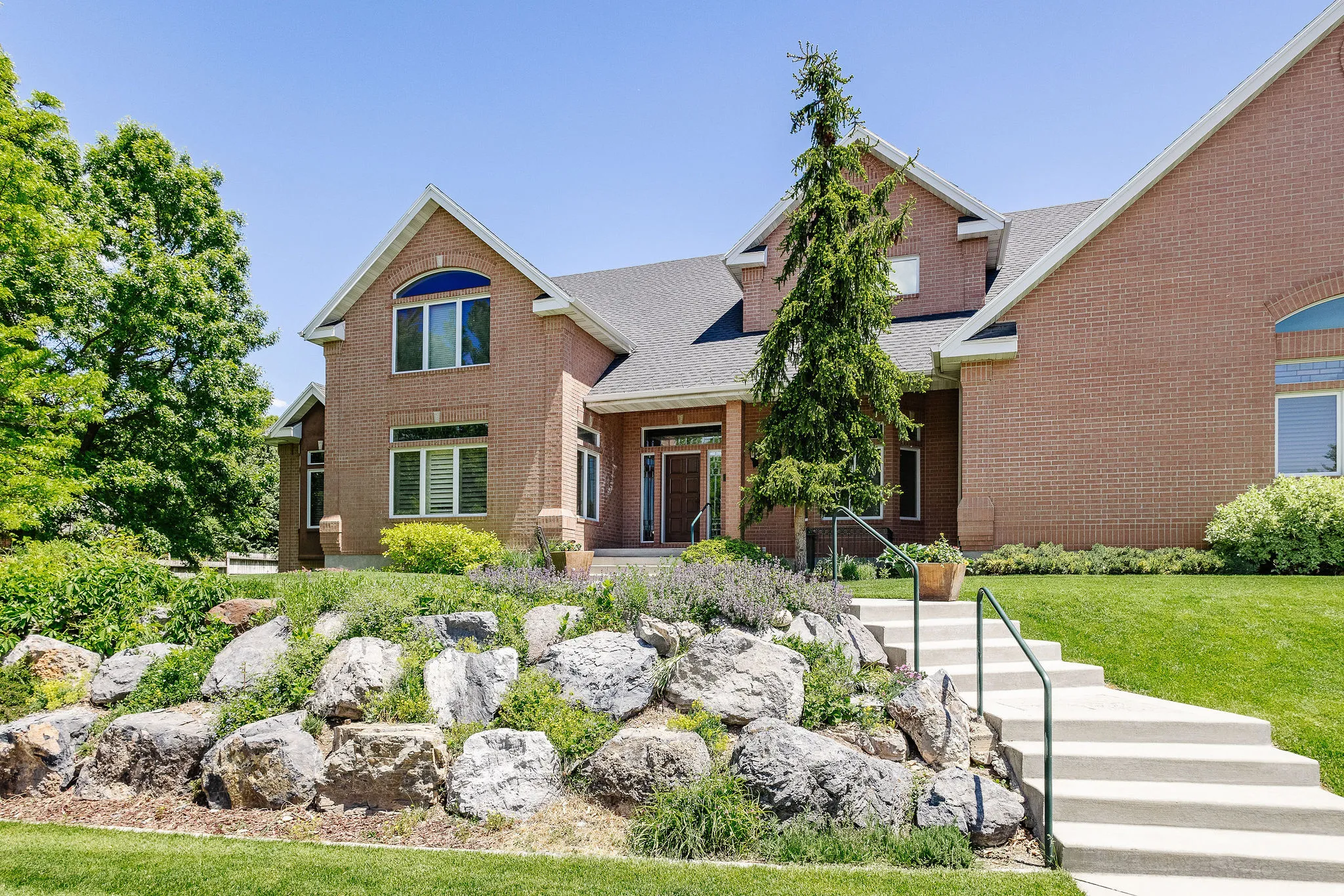 Brick exterior with multiple gables, arched windows, and a prominent entry
