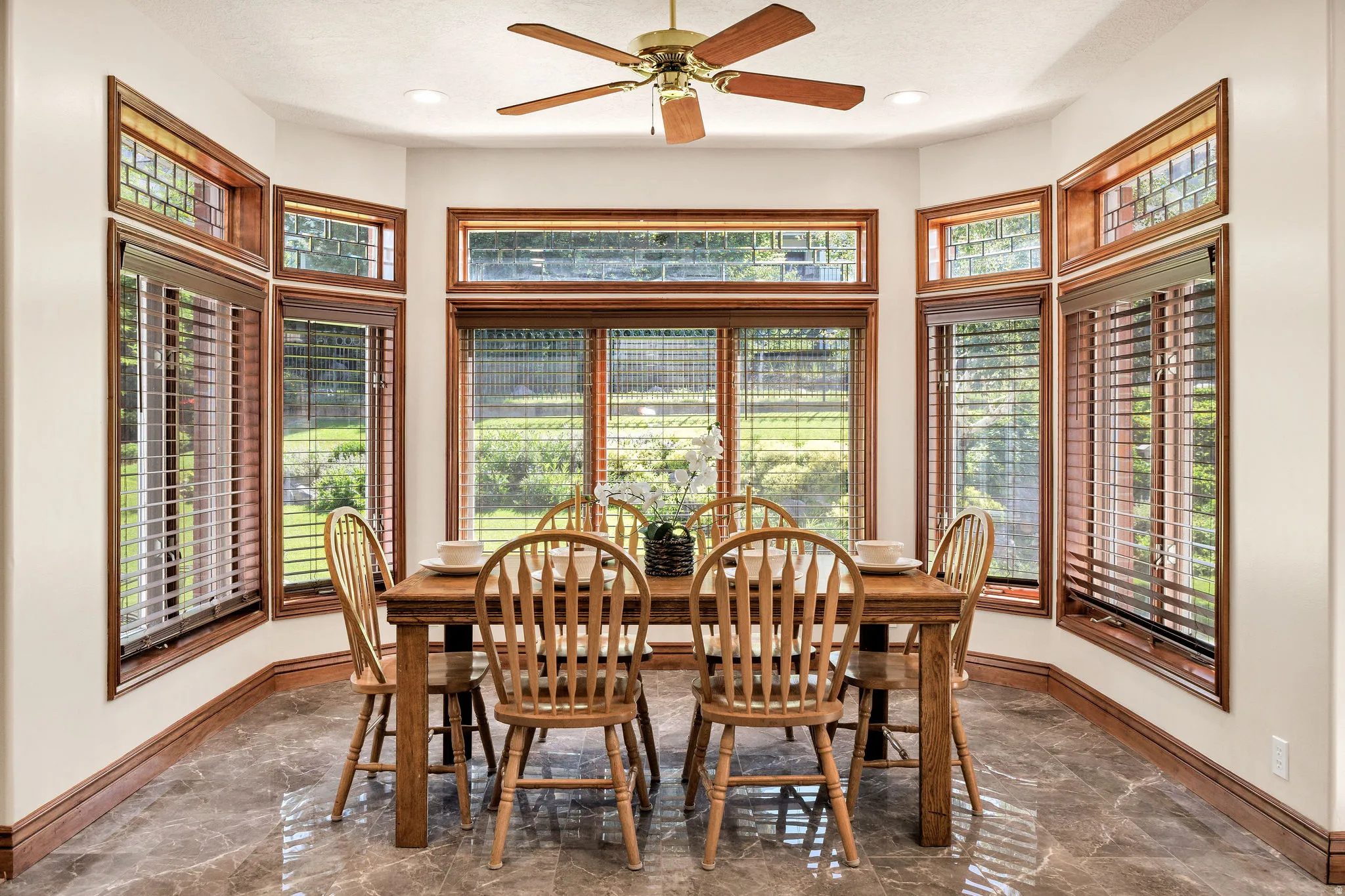 Bay window with wood-finish trim, a ceiling fan, recessed lighting, and tile flooring
