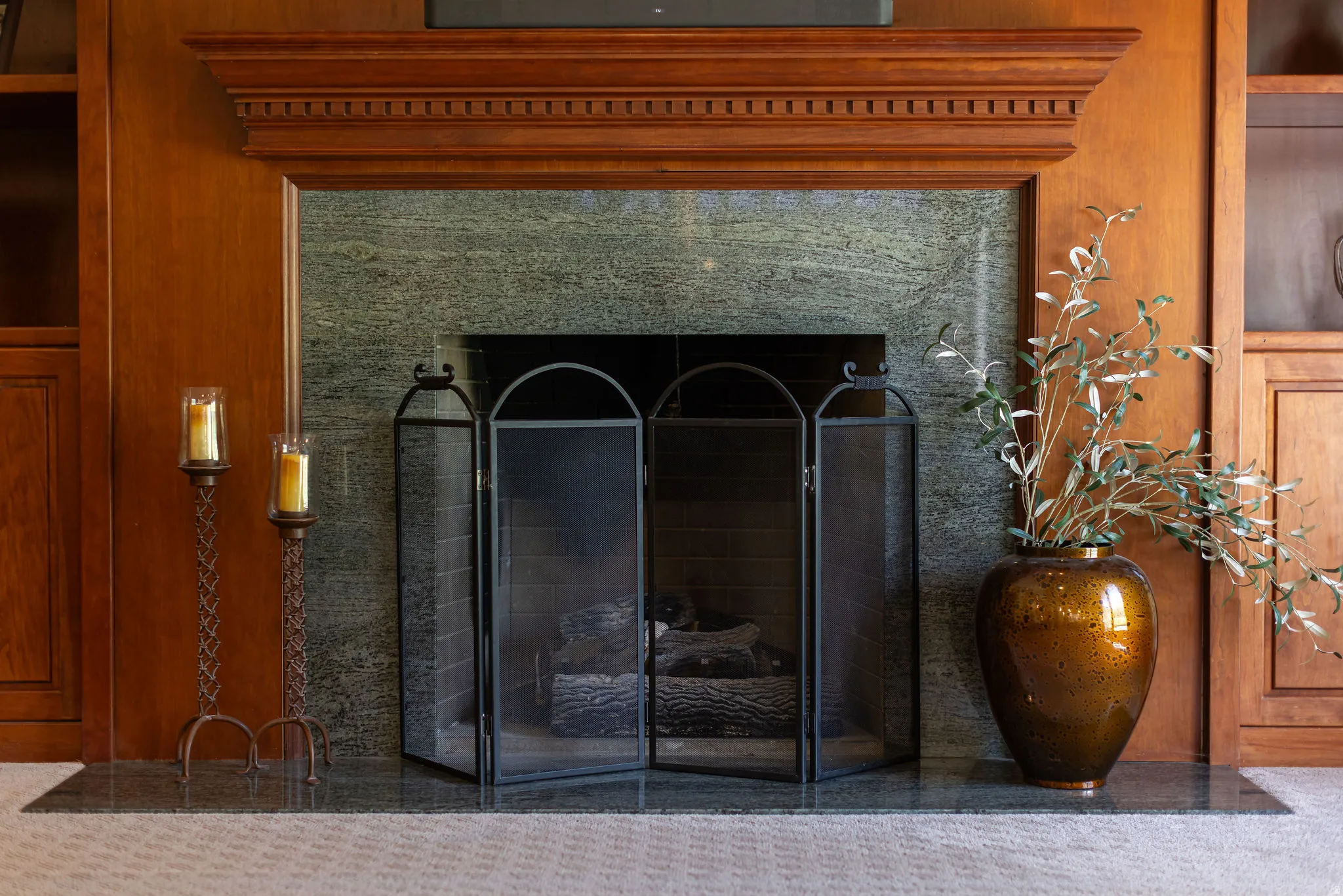 Fireplace featuring a decorative wood mantel, stone surround, and hearth