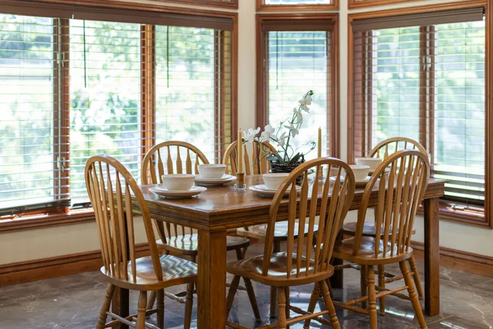 Bay window with wood-finish blinds, wood-trimmed windows, and dark tile flooring