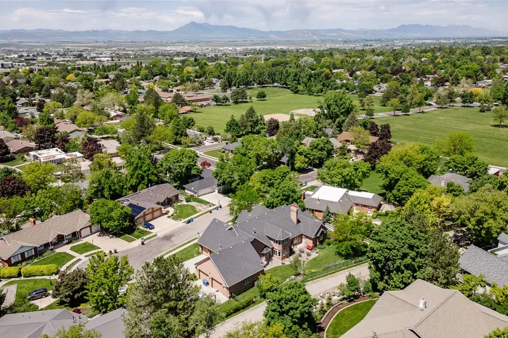 Expansive neighborhood with mature trees, green spaces, and mountain scenery