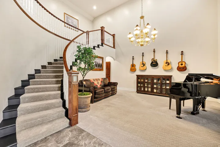 Grand entry featuring a curved staircase with wood banisters, white spindles, and carpeted treads