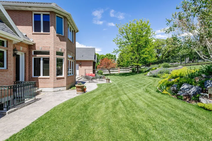 Brick exterior construction with multiple windows, leading to an expansive lawn area