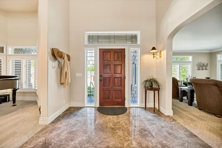 Grand entry featuring polished marble flooring and a solid wood front door